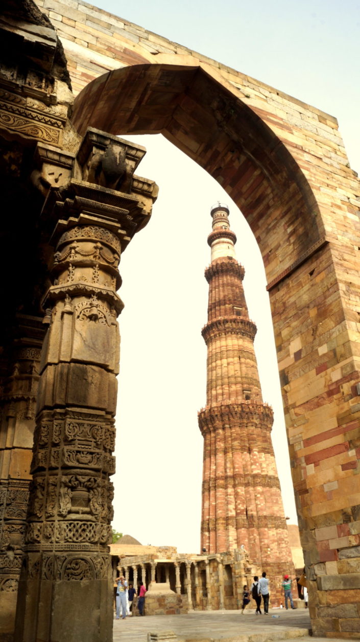 photography of Qutb Minar with a Jain temple reused pillar